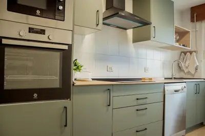 a kitchen with white cabinets and a stove top oven at A Paradiña de Sarria in Sarria