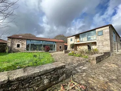 a large stone house with a stone wall at Residencia DO PICHO in Palas de Rei