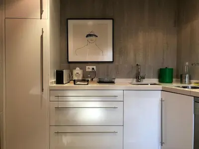 a kitchen with white cabinets and a picture on the wall at Residencia DO PICHO in Palas de Rei