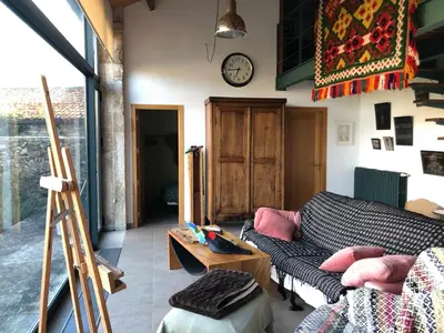 a living room with a couch and a clock on the wall at Residencia DO PICHO in Palas de Rei