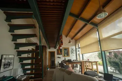 a living room with a spiral staircase in a house at Residencia DO PICHO in Palas de Rei