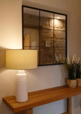 a lamp on a wooden shelf with a mirror at Casa San Blas in Verín