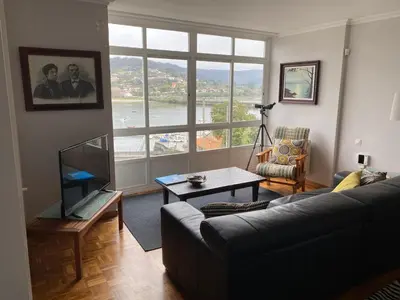 a living room with a couch and a large window at Vistas do Eume in Puentedeume