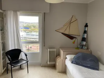a bedroom with a bed and a chair and a window at Vistas do Eume in Puentedeume