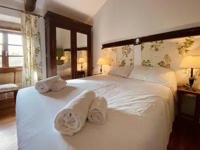 a bedroom with a large white bed with towels on it at Prioral Countryside Villa in Miño