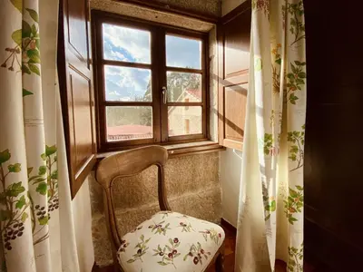 a chair sitting in front of a window at Prioral Countryside Villa in Miño