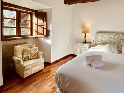 a bedroom with two beds and a chair and a window at Prioral Countryside Villa in Miño