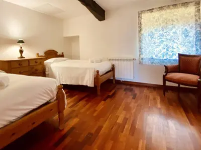 a bedroom with two beds and a chair and a window at Prioral Countryside Villa in Miño