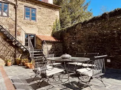 a patio with a table and chairs in front of a building at Prioral Countryside Villa in Miño