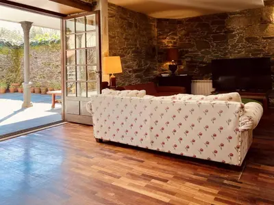 a living room with a couch and a sliding glass door at Prioral Countryside Villa in Miño