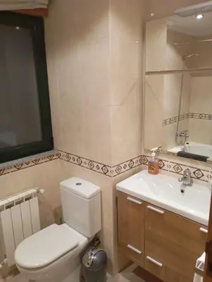 a bathroom with a white toilet and a sink at Piso ABELEDO in Sarria