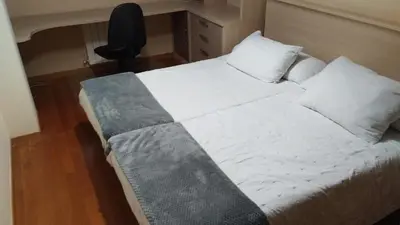 a bed with white sheets and pillows in a room at Piso ABELEDO in Sarria