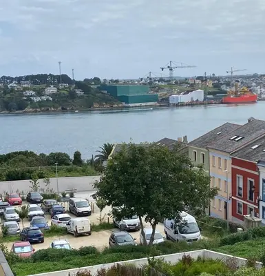 a parking lot with cars parked next to a river at Apartamento Miramar Ribadeo in Ribadeo