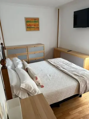 a bedroom with a bed with pillows and a television at Apartamento Miramar Ribadeo in Ribadeo