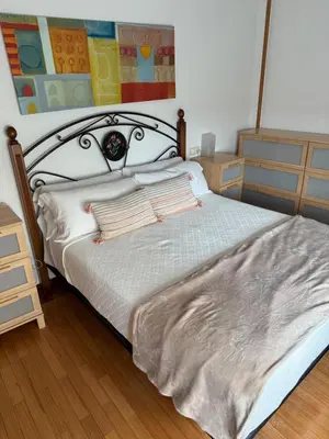 a bedroom with a bed with a blanket on it at Apartamento Miramar Ribadeo in Ribadeo