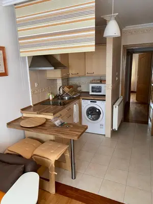 a kitchen with a table and a sink and a stove at Apartamento Miramar Ribadeo in Ribadeo