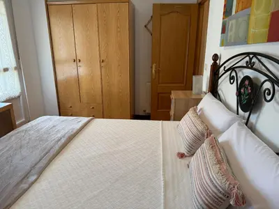a bedroom with a large white bed with pillows at Apartamento Miramar Ribadeo in Ribadeo