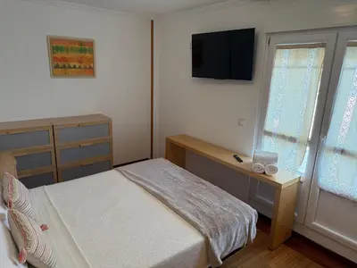 a bedroom with a bed and a desk and a television at Apartamento Miramar Ribadeo in Ribadeo