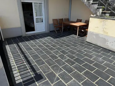 a patio with a table and chairs and a door at Apartamento Miramar Ribadeo in Ribadeo