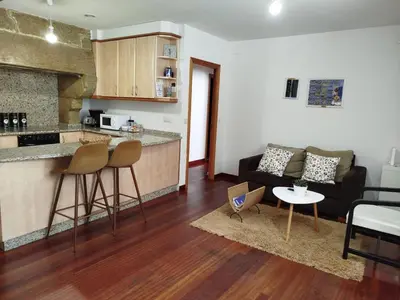 a kitchen and a living room with a couch and a table at Pensión 5 Caminos in Santiago de Compostela