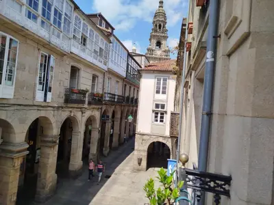 two people walking down a street between buildings at Pensión 5 Caminos in Santiago de Compostela