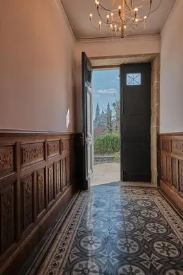an empty hallway with a door and a chandelier at Hotel Gaio 7 in Santiago de Compostela