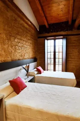 a bedroom with two beds and a window at Hostal Restaurante LA SENDA in Camponaraya