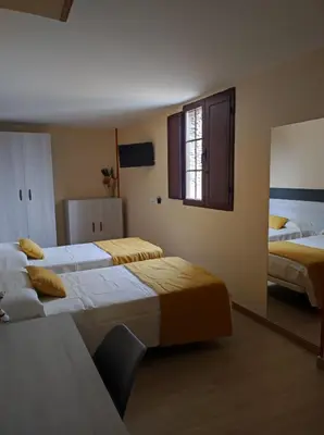 a hotel room with two beds and a window at Hostal Restaurante LA SENDA in Camponaraya