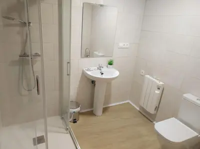 a bathroom with a sink and a shower and a toilet at Hostal Restaurante LA SENDA in Camponaraya