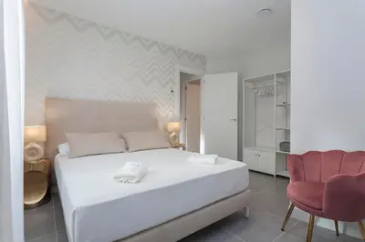 a bedroom with a white bed and a red chair at Apartamentos PUERTO DE VIAVELEZ in Viavélez