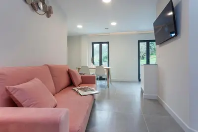 a living room with a couch and a flat screen tv at Apartamentos PUERTO DE VIAVELEZ in Viavélez