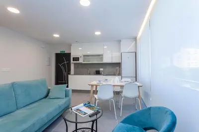 a living room with a blue couch and a table at Apartamentos PUERTO DE VIAVELEZ in Viavélez