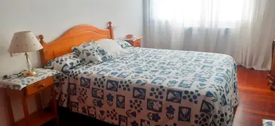 a bedroom with a bed with a blue and white blanket at Vivienda Maceda in Maceda