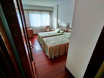 a bedroom with two beds and a window at Vivienda Maceda in Maceda