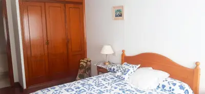a bedroom with a bed with blue and white pillows at Vivienda Maceda in Maceda