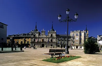 a street light and a bench in front of a building at BierzINN Alojamientos - Martina II in Ponferrada