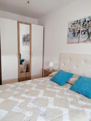 a bedroom with a large bed with two blue pillows at Estudio panorámico in Lugo