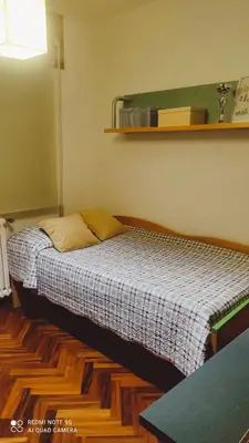 a bedroom with a bed and a shelf on the wall at Piso céntrico en Padrón in Padrón