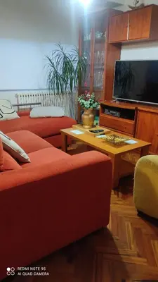 a living room with two red couches and a tv at Piso céntrico en Padrón in Padrón