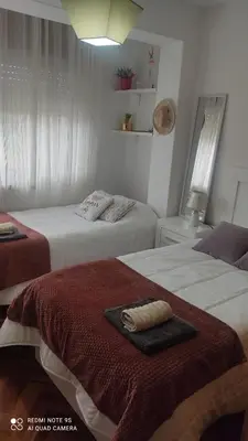 a bedroom with two beds with a towel on it at Piso céntrico en Padrón in Padrón