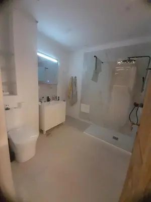 a white bathroom with a toilet and a sink at El refugio de las Burgas in Ourense