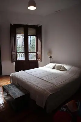 a large bed in a bedroom with a window at El refugio de las Burgas in Ourense