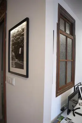 a picture hanging on a wall next to a window at El refugio de las Burgas in Ourense
