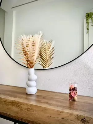 a vase on a table in front of a mirror at Cos pés en Palas in Palas de Rei