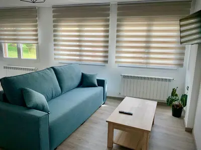 a living room with a blue couch and a coffee table at Cos pés en Palas in Palas de Rei