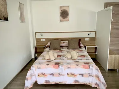 a bedroom with a large bed with a pink comforter at Cos pés en Palas in Palas de Rei