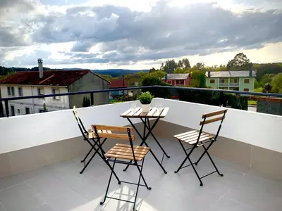 a balcony with two chairs and a table on a balcony at Cos pés en Palas in Palas de Rei