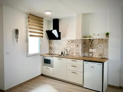 a kitchen with white cabinets and a sink at Cos pés en Palas in Palas de Rei