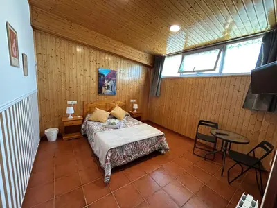 a bedroom with a bed and a table in a room at Pensión Codesal in O Pedrouzo