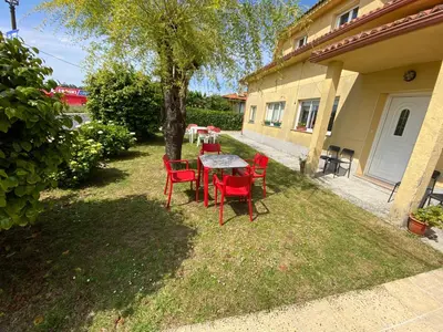 a table and chairs in the yard of a house at Pensión Codesal in O Pedrouzo